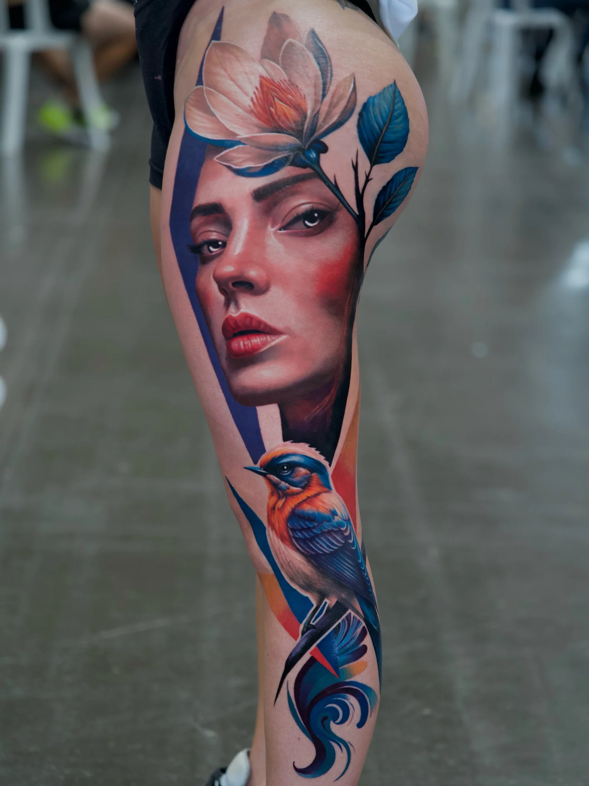 tatuaje de un rostro femenino realista con ornamentos en toda la pierna a color