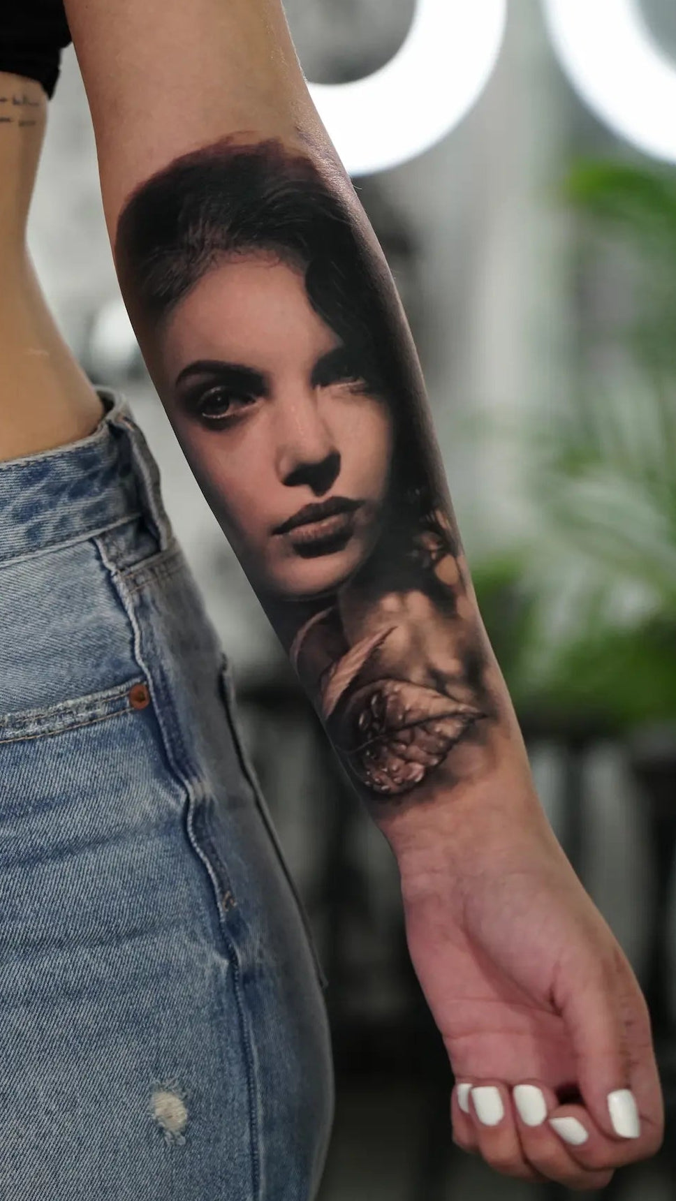 tatuaje de rostro femenino en el antebrazo en blanco y negro estilo realista